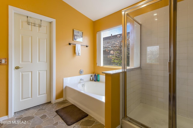 full bathroom with a stall shower, baseboards, and a garden tub