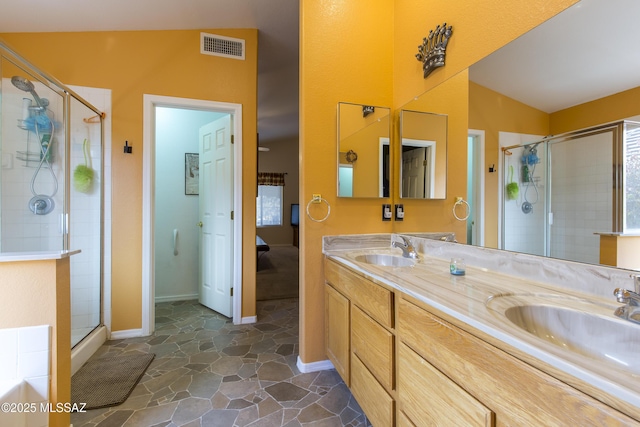 bathroom featuring double vanity, visible vents, a stall shower, and a sink