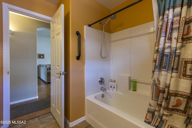 bathroom featuring shower / bathtub combination with curtain and baseboards