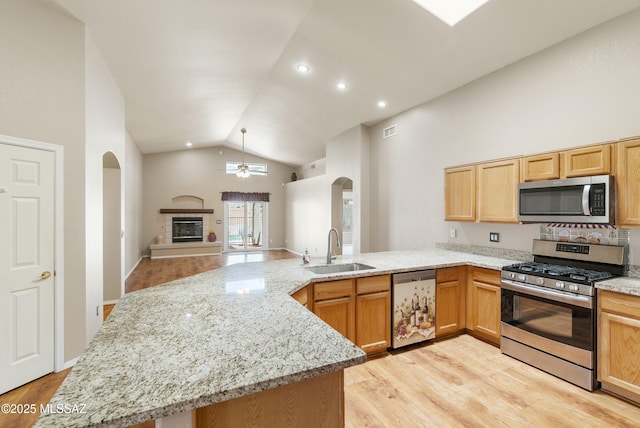 10187 E Watson Dr, Tucson, AZ 85730 - kitchen with stainless steel appliances, a sink, arched walkways, lofted ceiling, and a peninsula