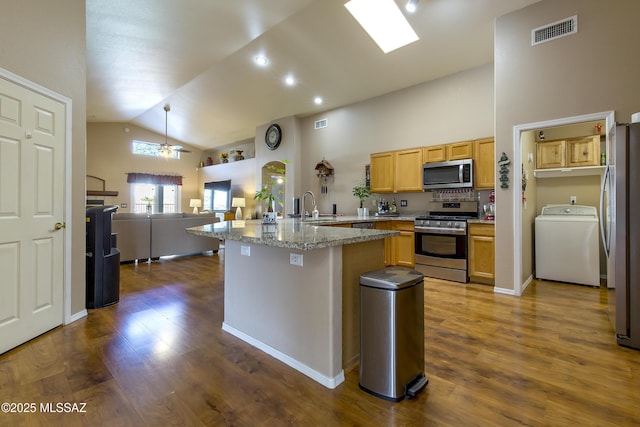 kitchen with visible vents, washer / dryer, a peninsula, a sink, and stainless steel appliances