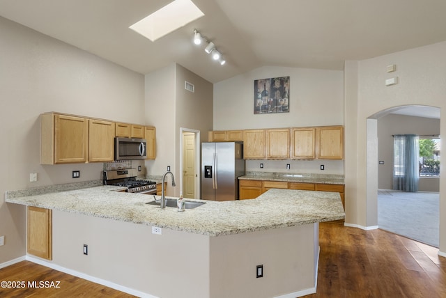 10187 E Watson Dr, Tucson, AZ 85730 - kitchen with appliances with stainless steel finishes, a sink, high vaulted ceiling, a peninsula, and arched walkways
