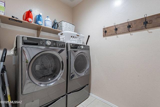 laundry room featuring washing machine and dryer and light tile patterned flooring