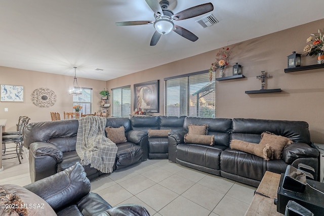 living room with light tile patterned floors and ceiling fan with notable chandelier