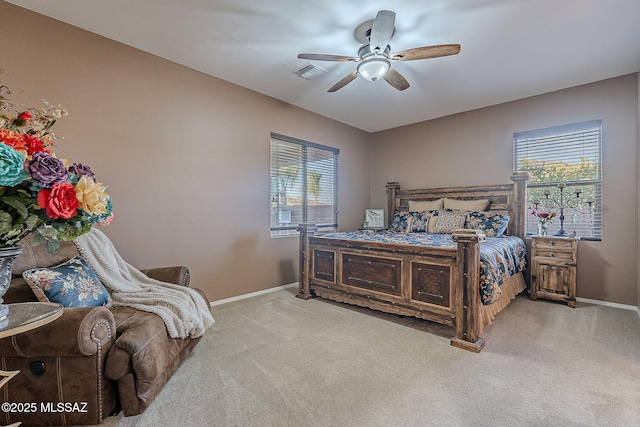 bedroom with ceiling fan, light carpet, and multiple windows