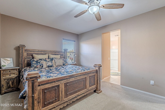 bedroom featuring light colored carpet, ensuite bath, and ceiling fan