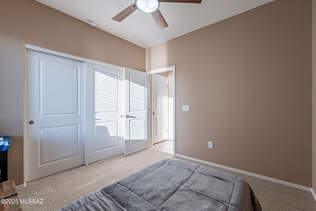 carpeted bedroom featuring ceiling fan and a closet