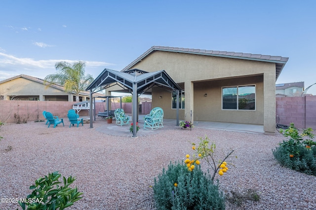 back of property featuring a gazebo and a patio area