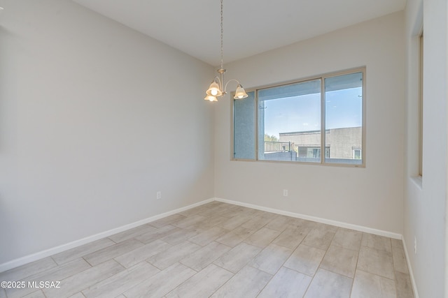 spare room with a notable chandelier