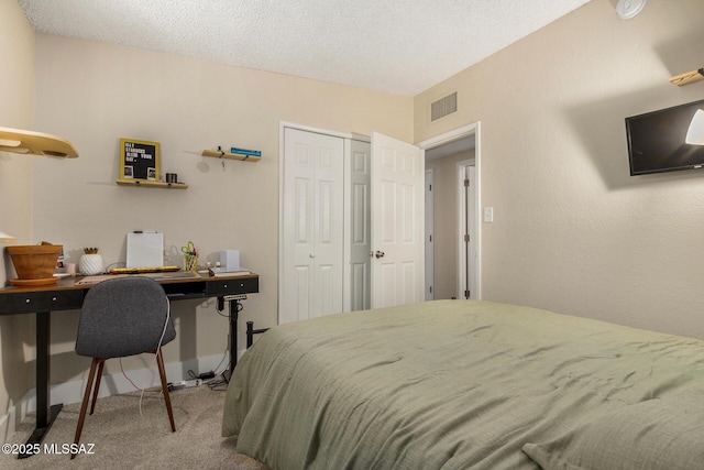 carpeted bedroom with a textured ceiling and a closet