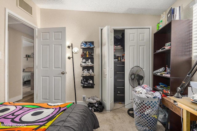 bedroom with a textured ceiling, a closet, and carpet flooring