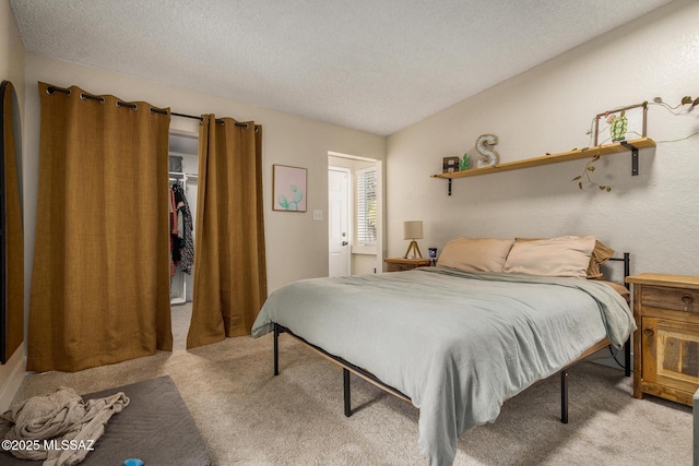 bedroom with a textured ceiling and light colored carpet