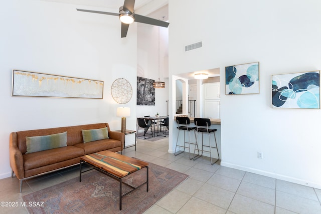 tiled living room with a towering ceiling and ceiling fan