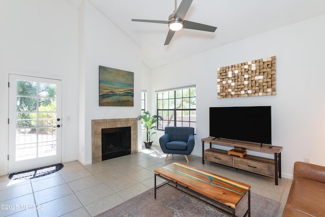 tiled living room featuring ceiling fan, a fireplace, high vaulted ceiling, and a healthy amount of sunlight