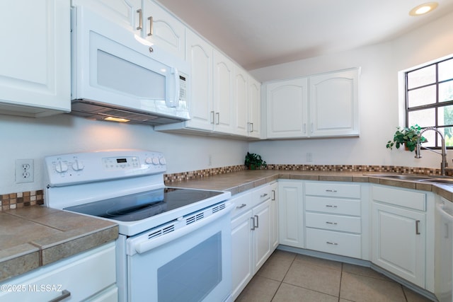 kitchen with sink, white cabinets, and white appliances