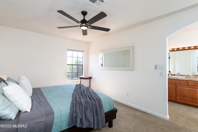 bedroom with ceiling fan, light colored carpet, sink, and connected bathroom