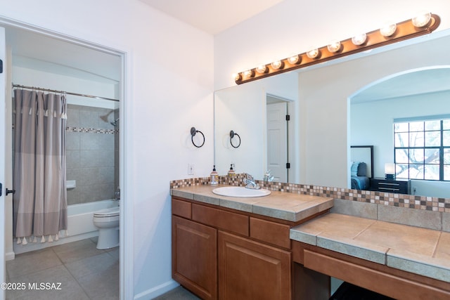 full bathroom featuring tile patterned flooring, vanity, toilet, and shower / bath combo with shower curtain