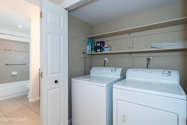 clothes washing area featuring washing machine and clothes dryer and light tile patterned floors