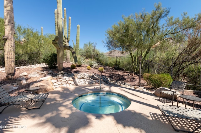 view of swimming pool featuring an in ground hot tub and a patio