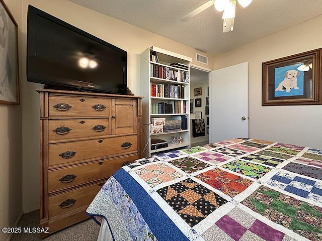 carpeted bedroom with ceiling fan and a textured ceiling