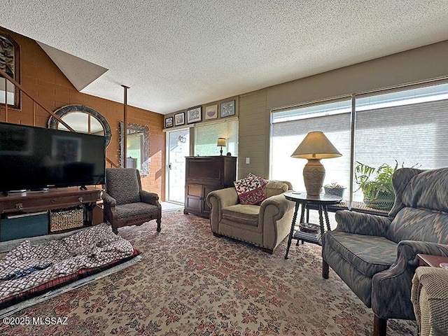 living room featuring wood walls and a textured ceiling