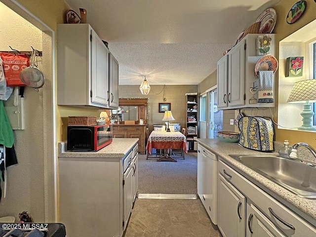 kitchen featuring white cabinetry, sink, white dishwasher, and a textured ceiling