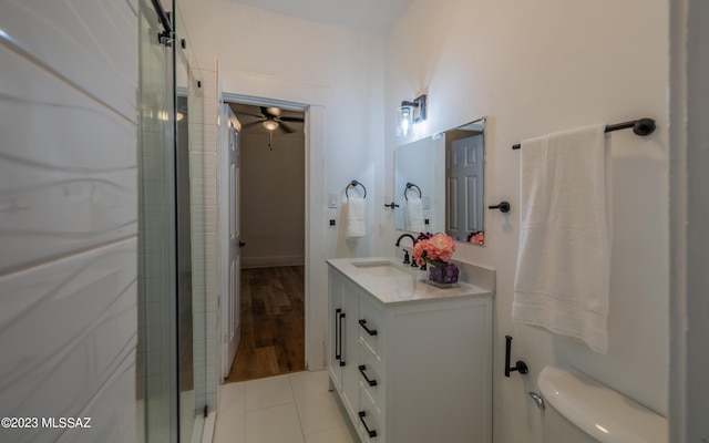 bathroom with ceiling fan, walk in shower, tile patterned floors, toilet, and vanity