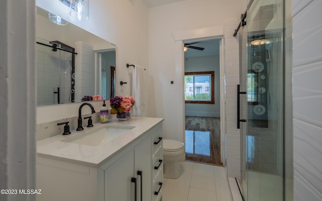 bathroom with toilet, vanity, tile patterned floors, and a shower with door