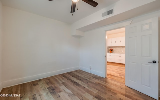 empty room with hardwood / wood-style flooring and ceiling fan