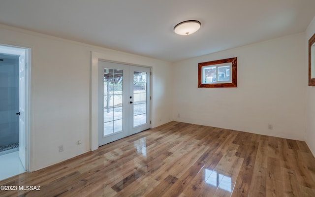 unfurnished room with french doors and light wood-type flooring