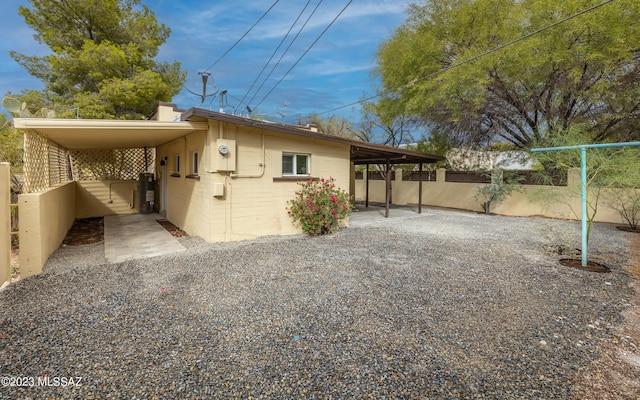 rear view of house featuring gas water heater and a carport