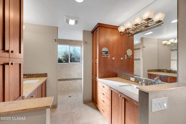 bathroom with tasteful backsplash, vanity, tile patterned flooring, and a shower