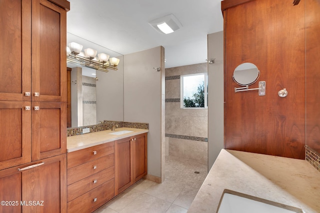 bathroom featuring a tile shower, tile patterned floors, tasteful backsplash, and vanity