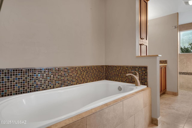 bathroom featuring vanity, tile patterned floors, and tiled tub