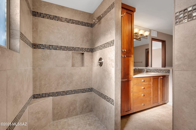 bathroom featuring vanity, decorative backsplash, and tiled shower