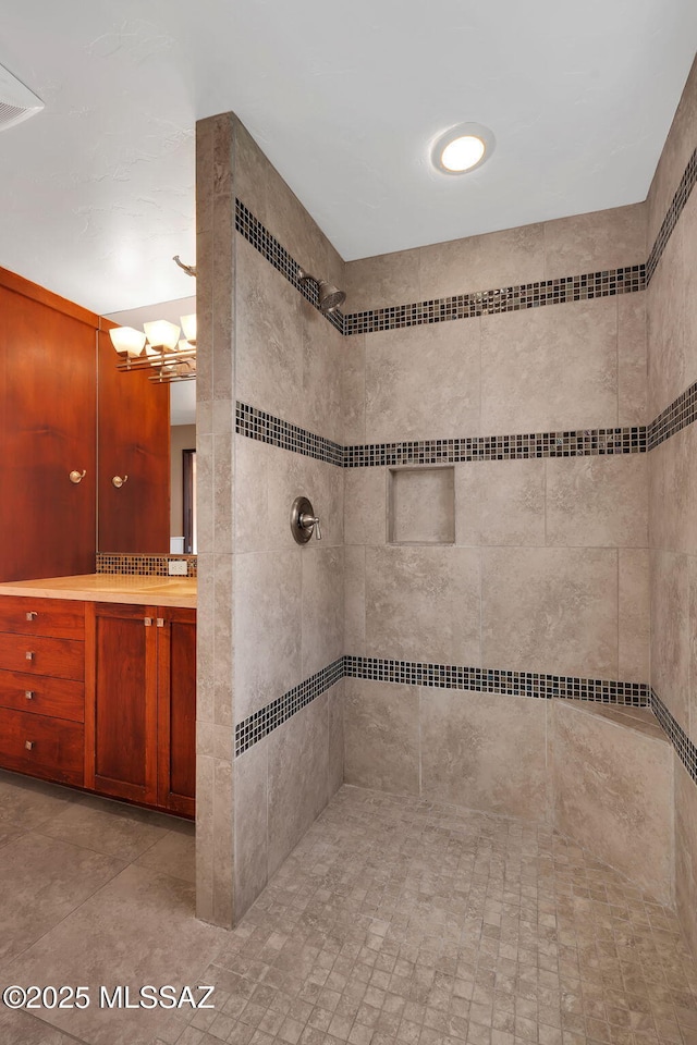 bathroom with vanity and a tile shower