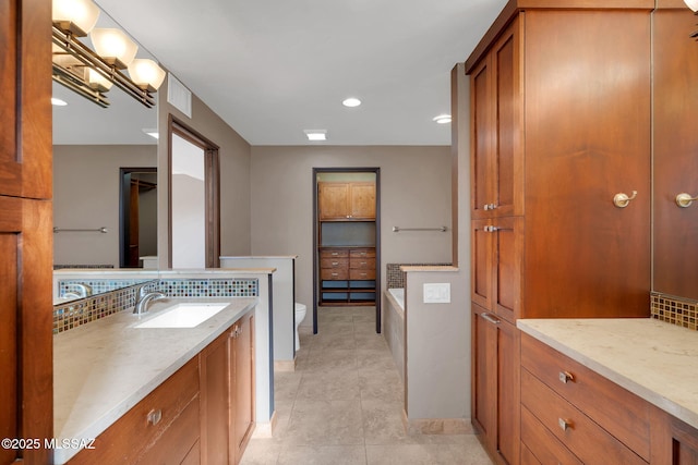 bathroom featuring toilet, a tub to relax in, backsplash, tile patterned flooring, and vanity