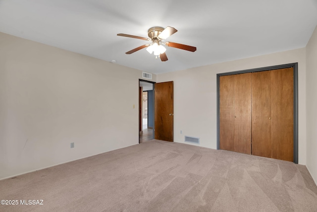 unfurnished bedroom with a closet, carpet flooring, and ceiling fan