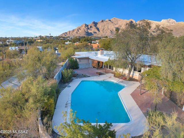 view of pool with a mountain view and a patio area