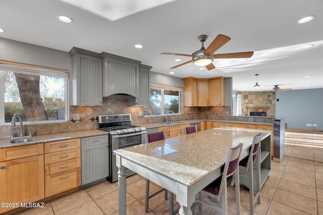 kitchen featuring light stone countertops, sink, gray cabinets, and stainless steel appliances