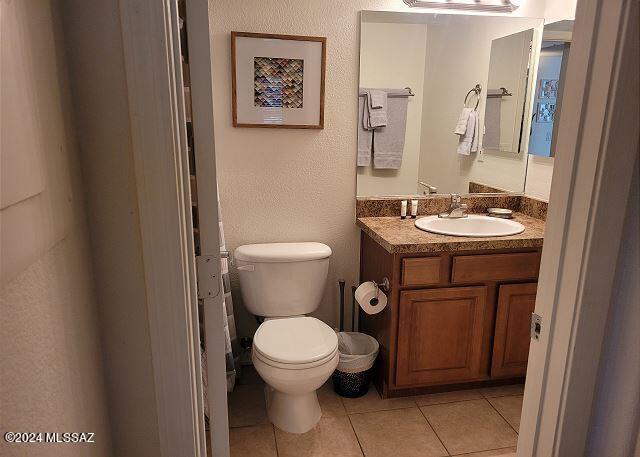 bathroom with tile patterned flooring, vanity, and toilet