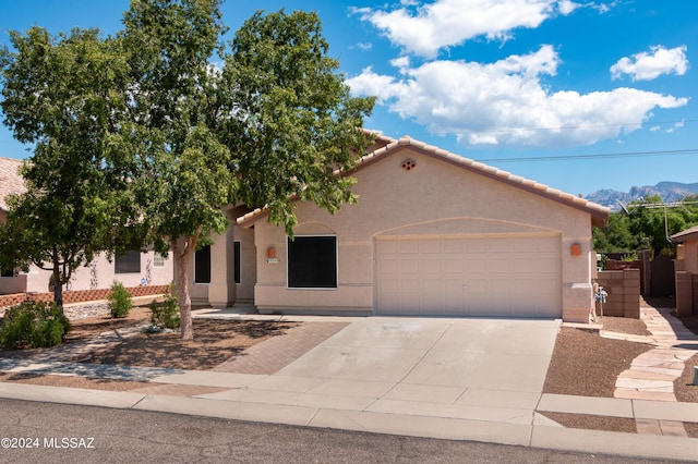 view of front of home featuring stucco siding, a garage, concrete driveway, and a tile roof