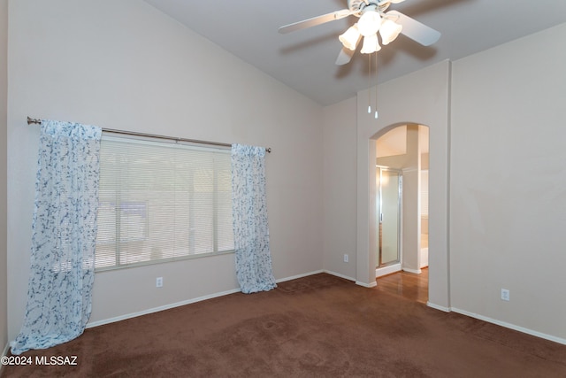 empty room featuring dark colored carpet, ceiling fan, and lofted ceiling