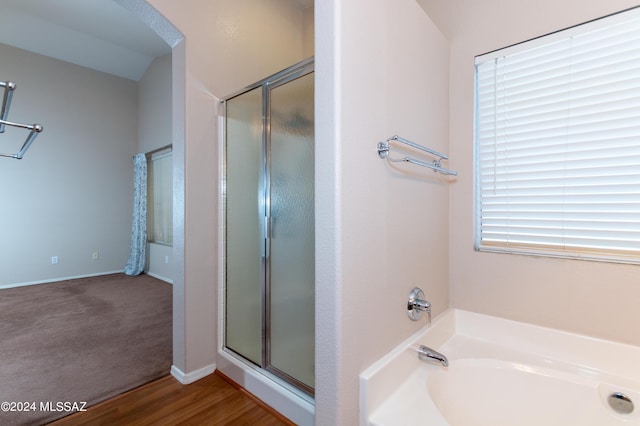 bathroom with hardwood / wood-style floors, lofted ceiling, and shower with separate bathtub