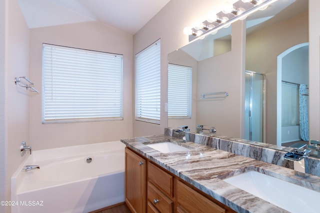 bathroom with vanity, vaulted ceiling, and shower with separate bathtub