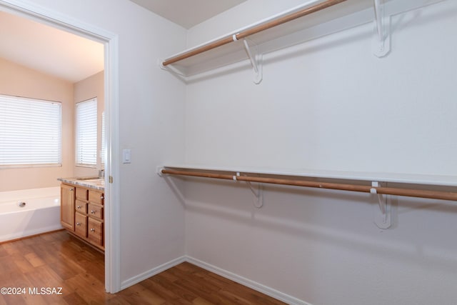 walk in closet with hardwood / wood-style floors and vaulted ceiling