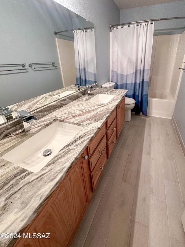 full bathroom featuring vanity, toilet, wood-type flooring, and shower / tub combo