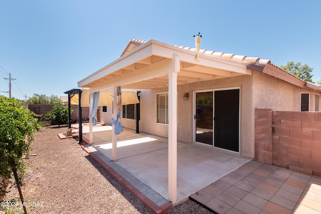 back of house with a pergola and a patio