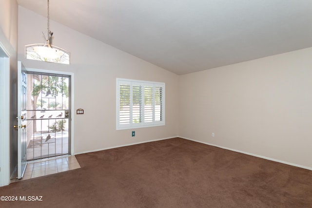 tiled entrance foyer with carpet floors, plenty of natural light, and high vaulted ceiling