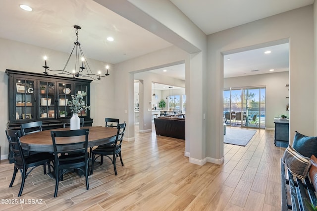 dining area with baseboards, a notable chandelier, recessed lighting, and wood finish floors